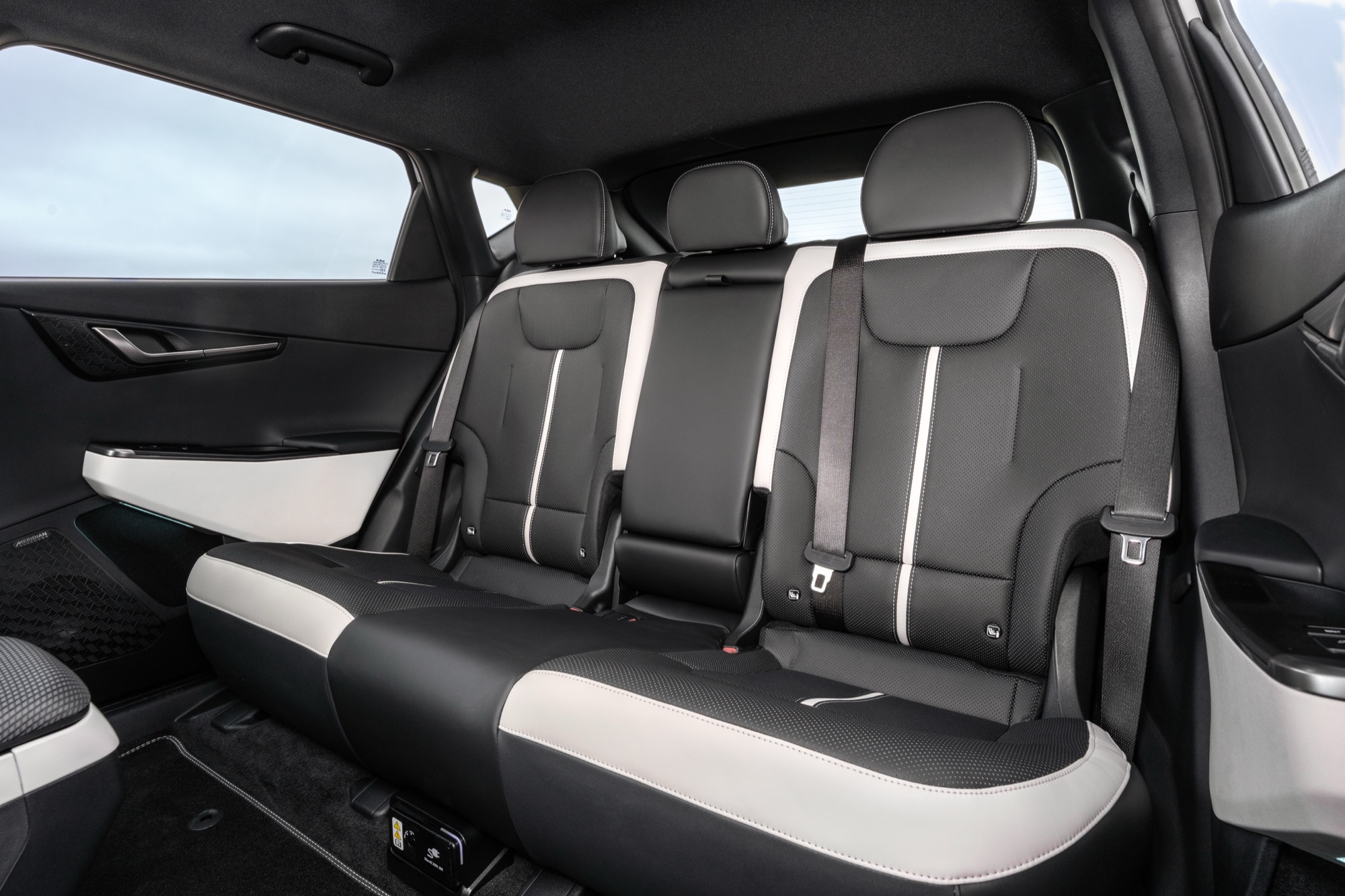 The rear seats, in black artificial suede with white bolsters